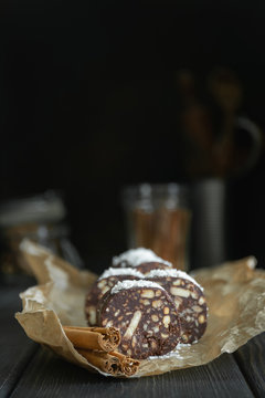 Vegetarian chocolate salami sprinkled with coconut and cut into slices on parchment.