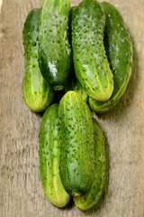 Fresh cucumbers on a wooden table close-up.
