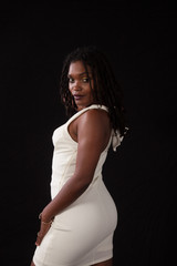 Black woman in a white dress, looking thoughtful