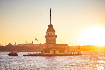 Fototapeta premium Fiery sunset over Bosphorus with famous Maiden's Tower (Kiz Kulesi in Turkish) also known as Leander's tower, symbol of Istanbul, Turkey