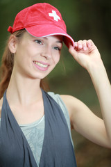 Jeune fille avec une casquette Suisse se promenant en forêt