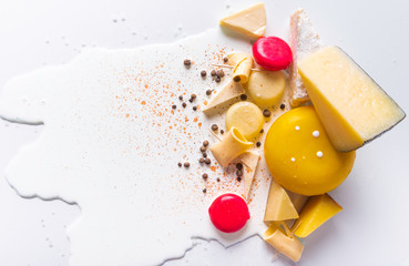 Various types of different cheese on puddle of milk and white isolated background. Symbols of jewish holiday - Shavuot