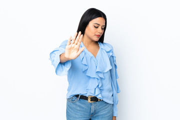 Young latin woman woman isolated on white background making stop gesture and disappointed