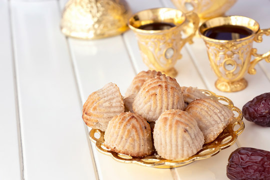 Maamoul traditional arab filled pastry or cookie with dates or cashew or walnut or almond or pistachios nuts. Eastern sweets. Close up. White wooden background.