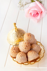 Maamoul traditional arab filled pastry or cookie with dates or cashew or walnut or almond or pistachios nuts. Eastern sweets. Close up. White wooden background.