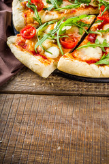 Flatbread homemade vegan pizza. Italian classic pizza with tomato cherry, mozzarella cheese and fresh arugula, copy space