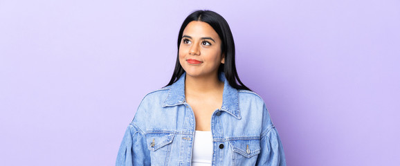 Young latin woman woman over isolated background thinking an idea while looking up