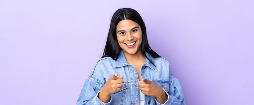 Young latin woman woman over isolated background surprised and pointing front
