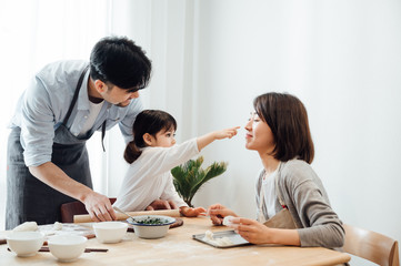 Mom and Dad and daughter at home dumplings