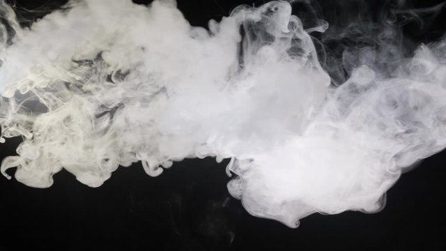 A man smokes a vape on a black background close-up. Slow motion