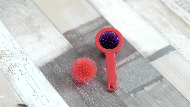 on the floor, two balls of purple and pink color are lying on the laminate floor in medium plan, with a magnifying glass, similar to a coronavirus. Laminate with a beautiful grey texture