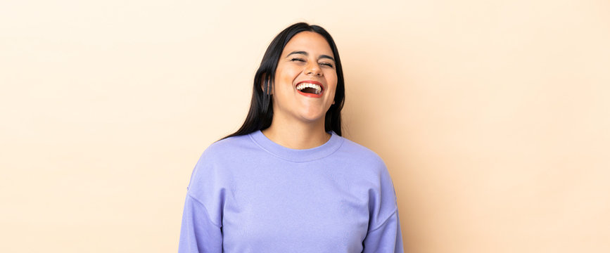 Young latin woman woman over isolated background laughing
