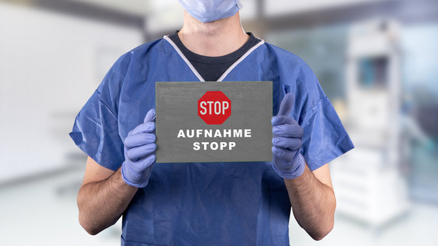 Arzt mit Schild auf dem Aufnahmestopp steht, Klinik hintergrund