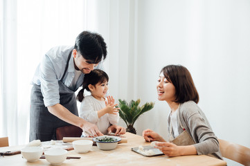 Obraz premium Mom and Dad and daughter at home dumplings