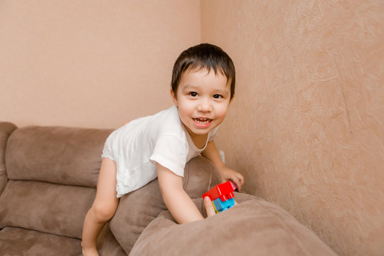 Toddler Boy Brunette Plays At Home on the Couch