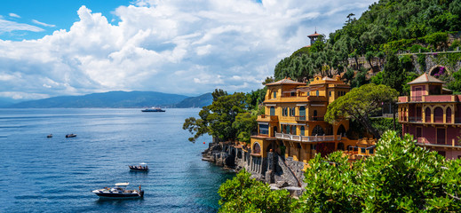 Fototapeta premium Scenic picture-postcard view of famous with wonderful gulf, luxury villas in mediterranean garden, rock and boats, yachts in spectacular vacation resort, Portofino, Liguria, Italy, Europe.