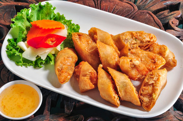 Deep fried shrimp-rolled Served with plum sauce on a white plate on a wooden table