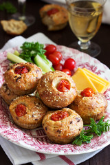 Muffins with cheese, cottage cheese and tomatoes, vegetables and cheese served with wine.