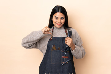 Young Colombian woman hairdresser isolated on beige background proud and self-satisfied