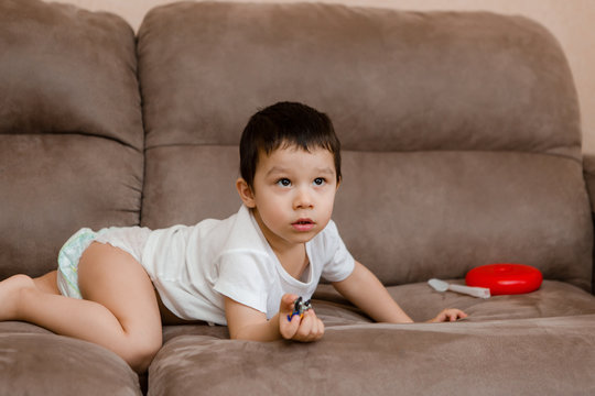 Toddler Boy Brunette Plays At Home on the Couch