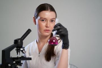portrait of a girl doctor with a microscope