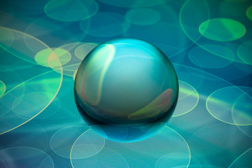 Crystal glass ball is lying on a stone surface on the colorful abstract background.