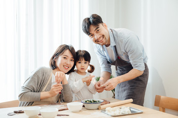 Mom and Dad and daughter at home dumplings