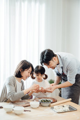 Mom and Dad and daughter at home dumplings