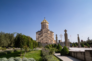 Fototapeta na wymiar Tbilisi, Georgia - 11/10/2018: Big main orthodox cathedral St. Trinity or Tsminda Sameba in Tbilisi city in Georgia and blue sky