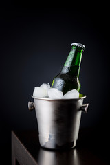 Bottle of beer in ice bucket on bar counter
