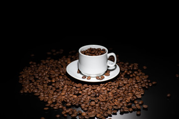 Cup with coffee beans on a dark background
