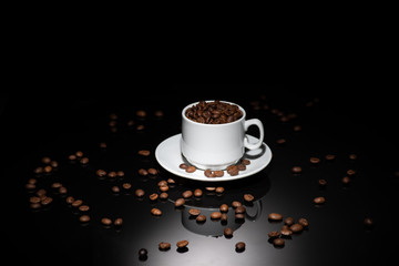 Cup with coffee beans on a dark background