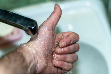 Male hand. Hand washing with water in the sink.