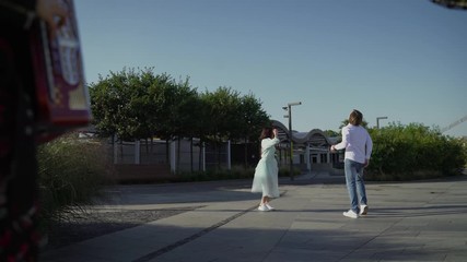 A young couple dancing outdoors under the button accordion. Young Russian guys dance Spanish dance to live music.