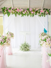 White and blue wooden arch at wedding ceremony with row of wedding chair decorated with white and pink flower.
