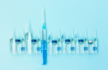 injection ampoules, syringe for vaccination on a blue background, healthcare coronavirus, cancer,...