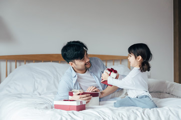 Father and daughter at home opening presents