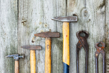 Set of vintage hand construction and carpentry tools hammers on a old wooden background, retro...