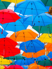 Fototapeta na wymiar a large number of bright and colorful umbrellas suspended in the sky