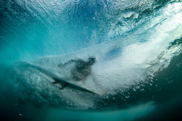 underwater shot of a surfer riding a tube or barrel overhead