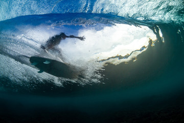 underwater shot of a surfer riding a tube or barrel overhead