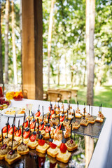 on a wooden table in the wedding banquet area are snacks, fruits, sweet cakes and muffins and lemonade drink