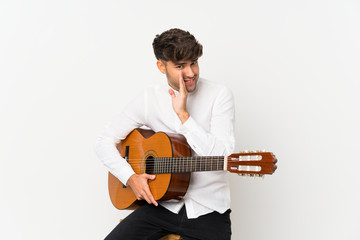 Obraz premium Young handsome man with guitar over isolated white background whispering something