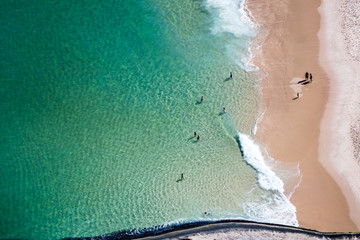 aerial view of people enjoying the beach and waves
