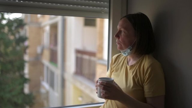 Woman in self-isolation during virus outbreak drinking coffee