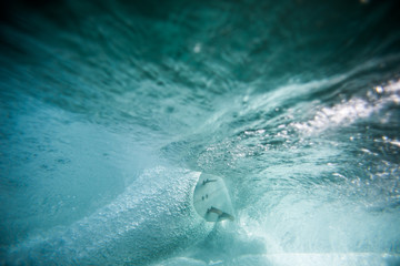surfer riding surfboard from underwater