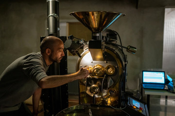 The man who controls the coffee as it turns and roasts in a roasting cauldron