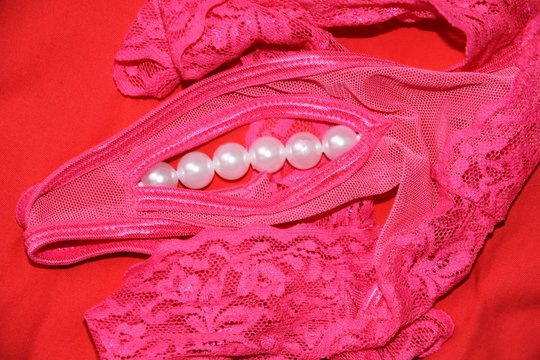 Close up of a pink woman panties decorated by pearls