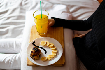 Woman having breakfast in bed in the morning.
