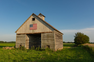 Obraz premium Old wooden barn with american flag.